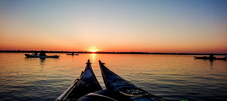 Kayaks with a sunset in the background