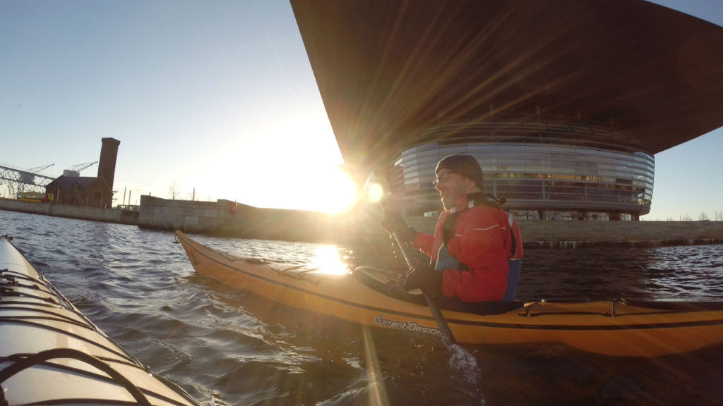 Kayak rower with sun in the background